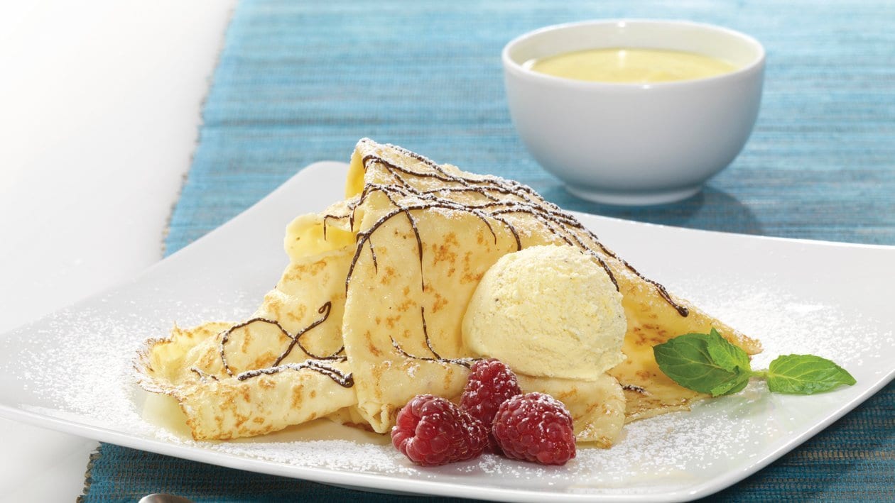 Crêpes mit Vanilleeis, Schokoladensauce und Himbeeren