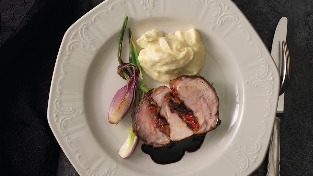 Rôti de porc farci aux fruits secs, pomme purée et oignons sautés Rôti de porc farci aux fruits secs, pomme purée et oignons sautés