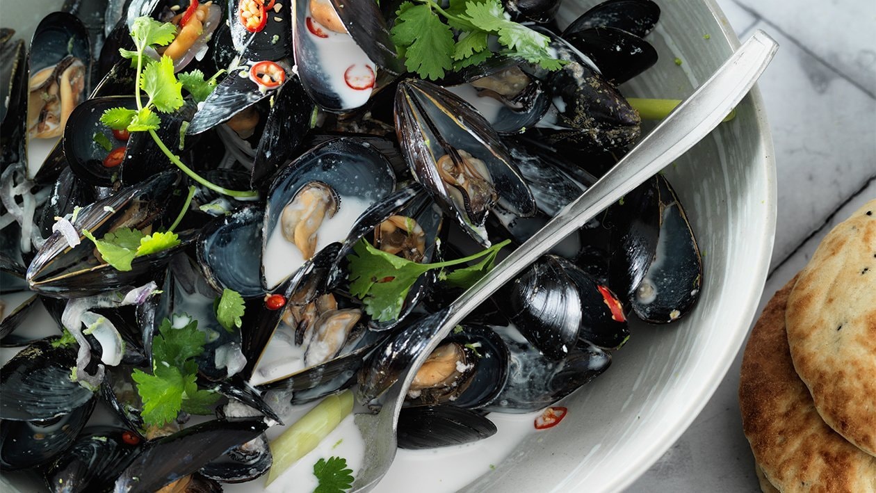 Moules dans un fond de noix de coco et roti canai Moules dans un fond de noix de coco et roti canai
