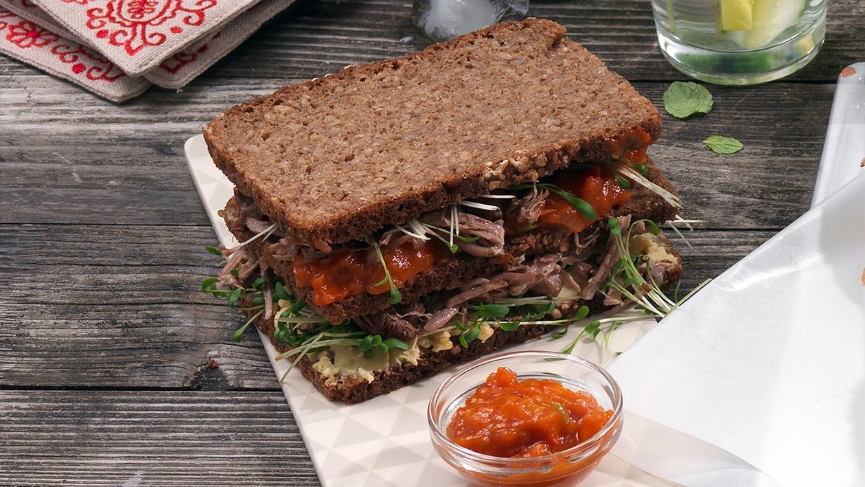 Sandwich de pumpernickel à l'épaule d'agneau effilochée