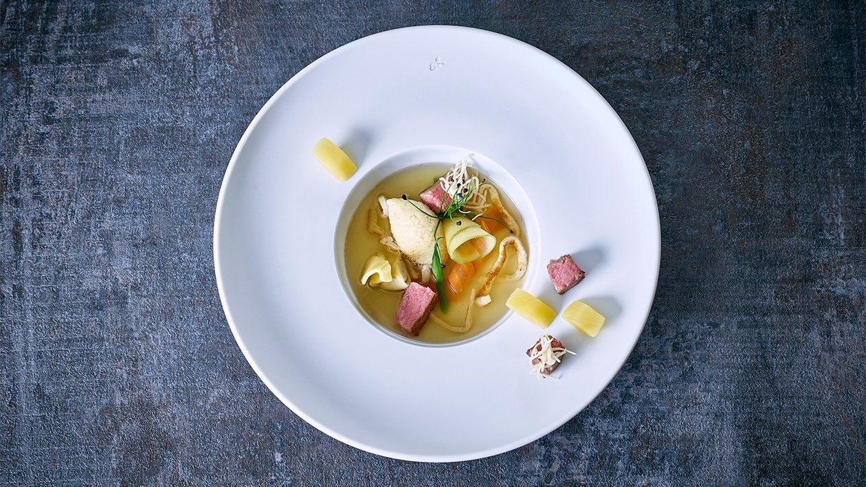 Consommé de boeuf aux aiguillettes de veau, quenelles de semoule et lanières de crêpe Consommé de boeuf aux aiguillettes de veau, quenelles de semoule et lanières de crêpe