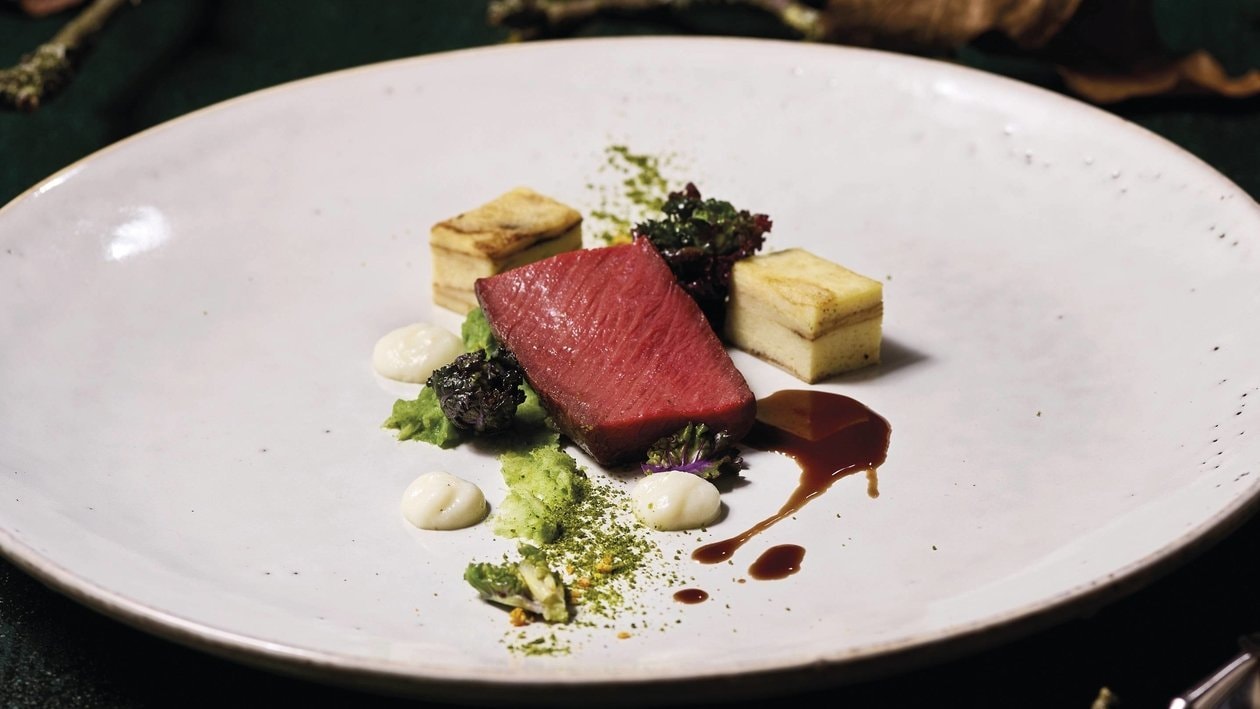 Im Gewürzfond pochiertes Hirschfilet mit Rotweinsauce, Kartoffelbaumkuchen, Rosenkohlpüree und Mandelgelee Im Gewürzfond pochiertes Hirschfilet mit Rotweinsauce, Kartoffelbaumkuchen, Rosenkohlpüree und Mandelgelee
