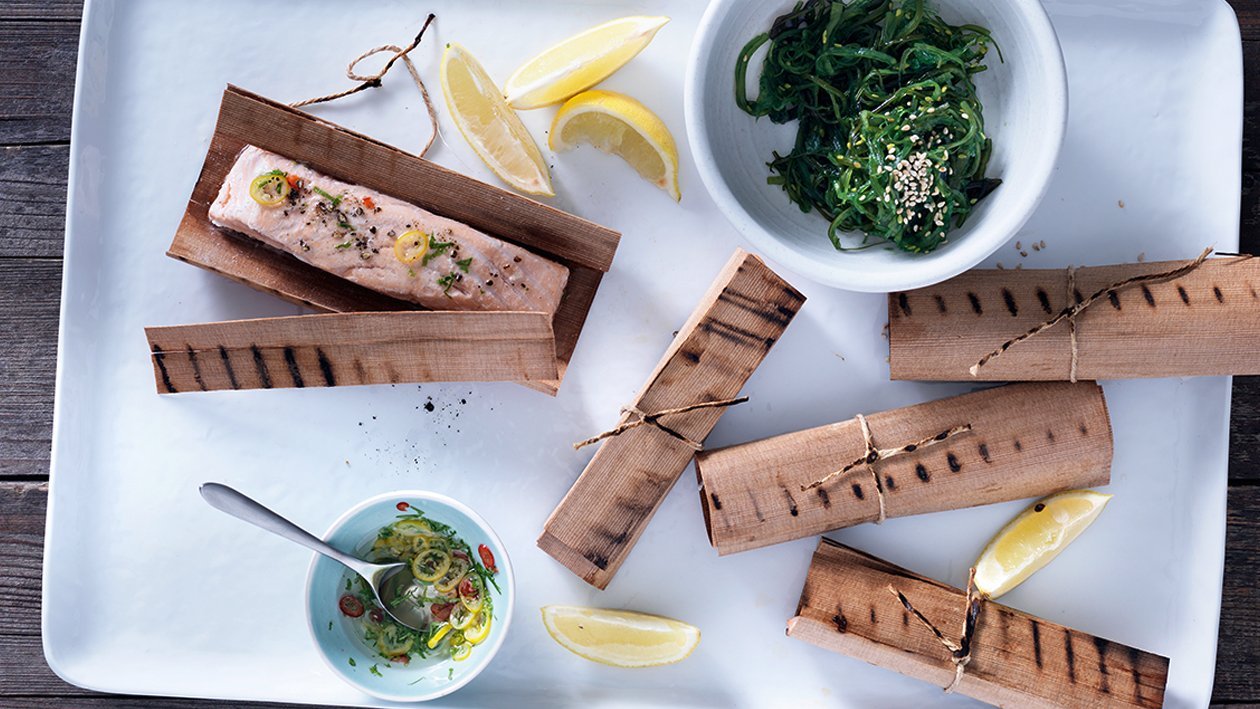 Im Holzpapier grillierter Lachs mit Wakame-Salat und Zitrus Vinaigrette