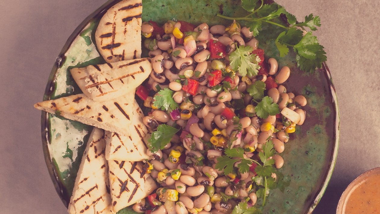 Salat Bowl mit Augenbohnensalat, Pitta-Brot und Ost-Afrikanischem Dressing Salat Bowl mit Augenbohnensalat, Pitta-Brot und Ost-Afrikanischem Dressing