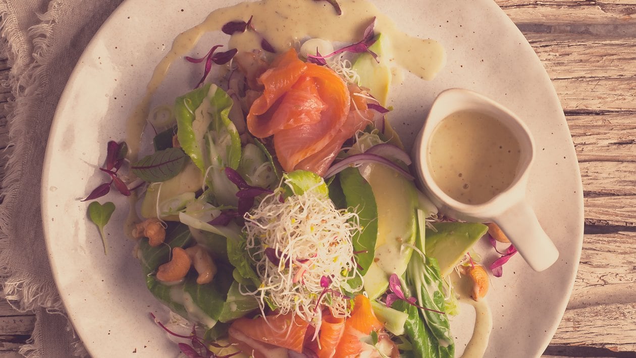 Salade de truite saumonée fumée, pak choi et avocat, feuilles de salade, germes alfa-alfa et un dressing épicé