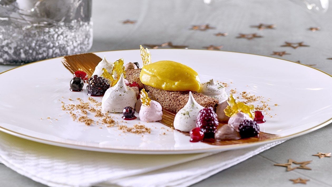 Schokoladenkuchen mit Lebkuchenmousse, Glühweincreme, Beeren und Passionsfruchteis