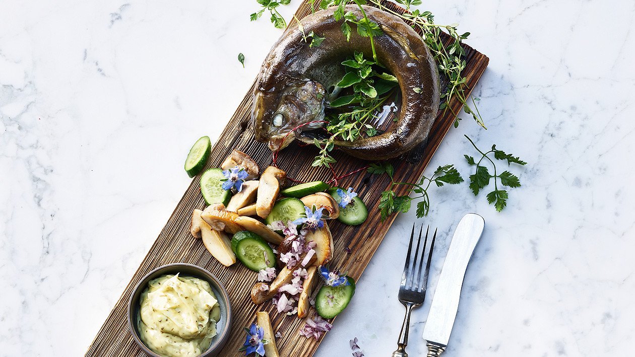 Forelle auf dem Holzbrett vom Grill mit Steinpilz-Gurkensalat Forelle auf dem Holzbrett vom Grill mit Steinpilz-Gurkensalat
