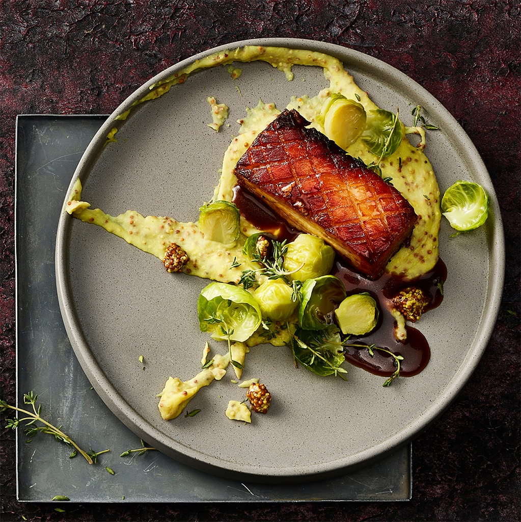 Poitrine de porc glacée sur purée de pommes de terre à la moutarde et choux-de-Bruxelles