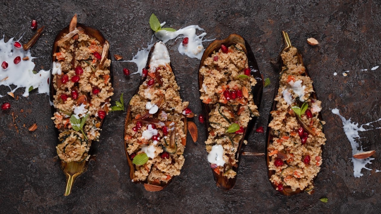 Couscous-Mandel-Dattel-Salat im Auberginenschiff mit Knoblauch-Joghurt und Pfefferminze