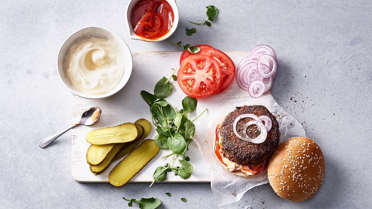 Burger de boeuf avec sauce à l'ail, cresson et concombres au vinaigre Burger de boeuf avec sauce à l'ail, cresson et concombres au vinaigre
