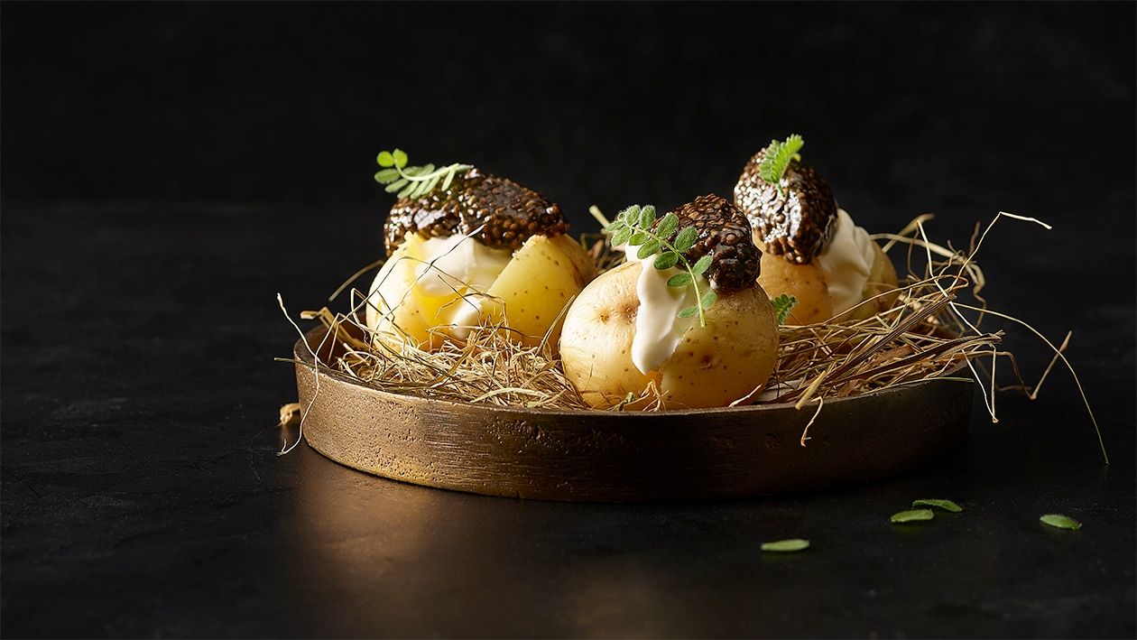 Caviar végane, pommes de terre et crème acidulée sur lit de foin Caviar végane, pommes de terre et crème acidulée sur lit de foin