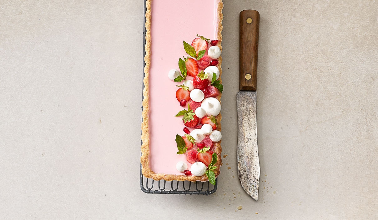 Tarte crémeuse à la rhubarbe, garnie de fraises et de mini-meringues –  