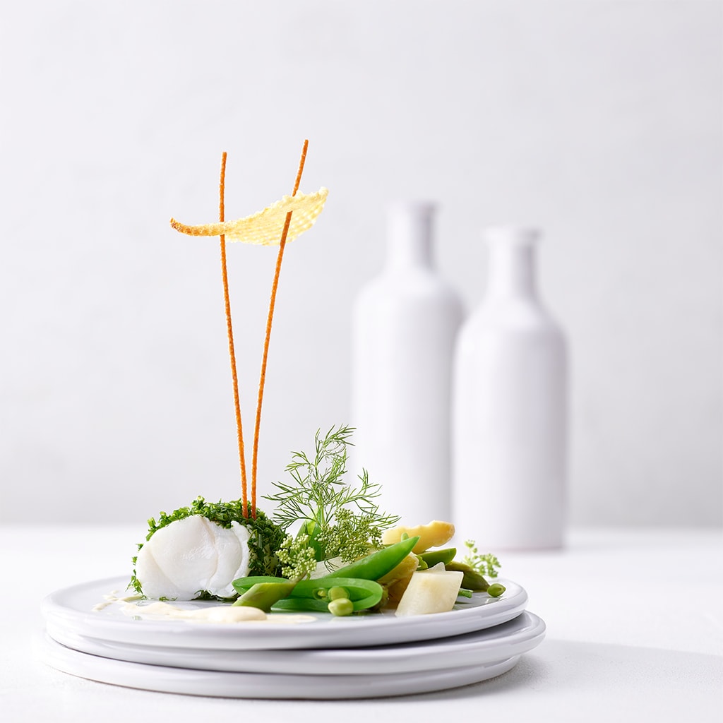 Pochierter Seeteufel im Kräutermantel mit Frühlingsgemüse und Tahiti-Vanille-Emulsion