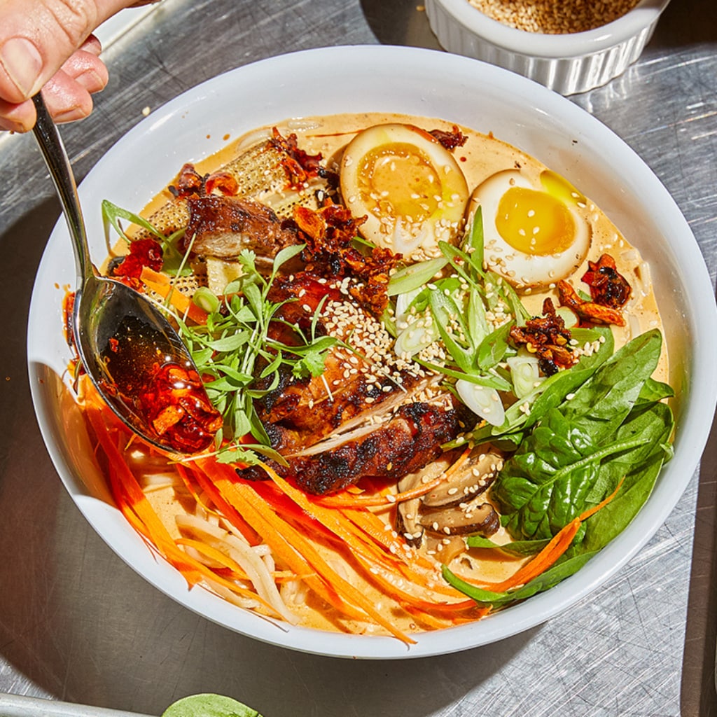 Pikante cremige rote Ramen mit auf dem Grill glasiertem Pouletschenkel