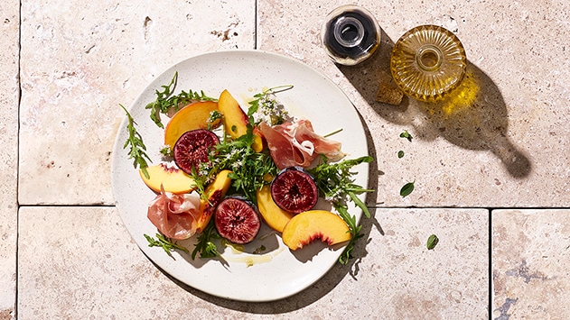 Salade estivale aux figues, pêches au jambon de Parme et roquette –  