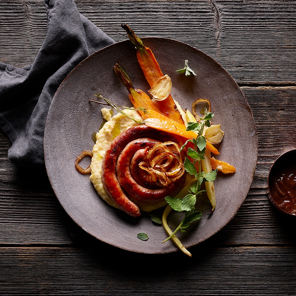 Grillierte Schweinsbratwurst mit Polenta und Ofenkarotten