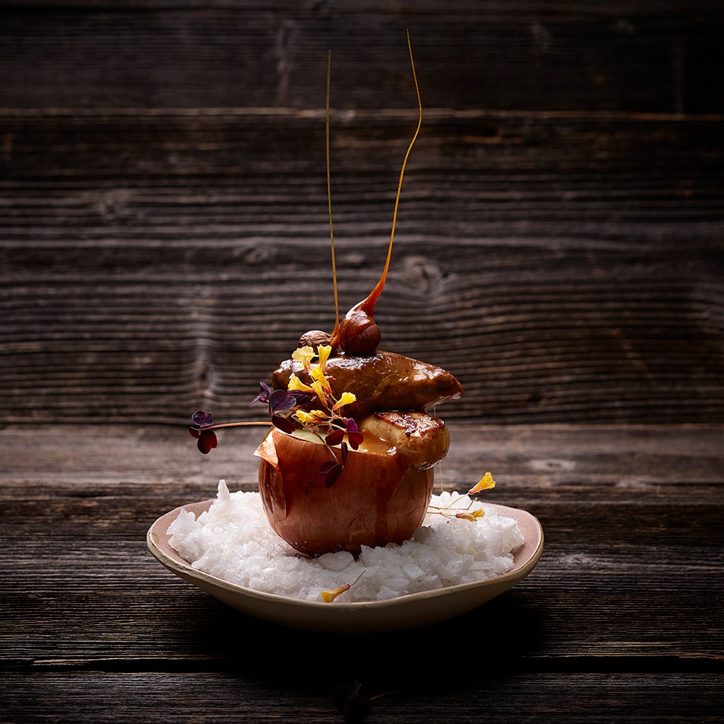 Schweinskopfbäckchen mit sautierter Gänseleber auf gebackener Zwiebel