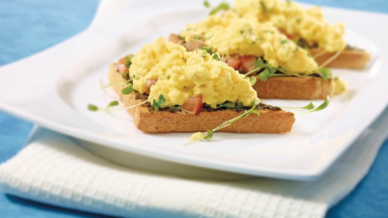 Oeufs brouillés sur croûtons aux olives et tomates –  
