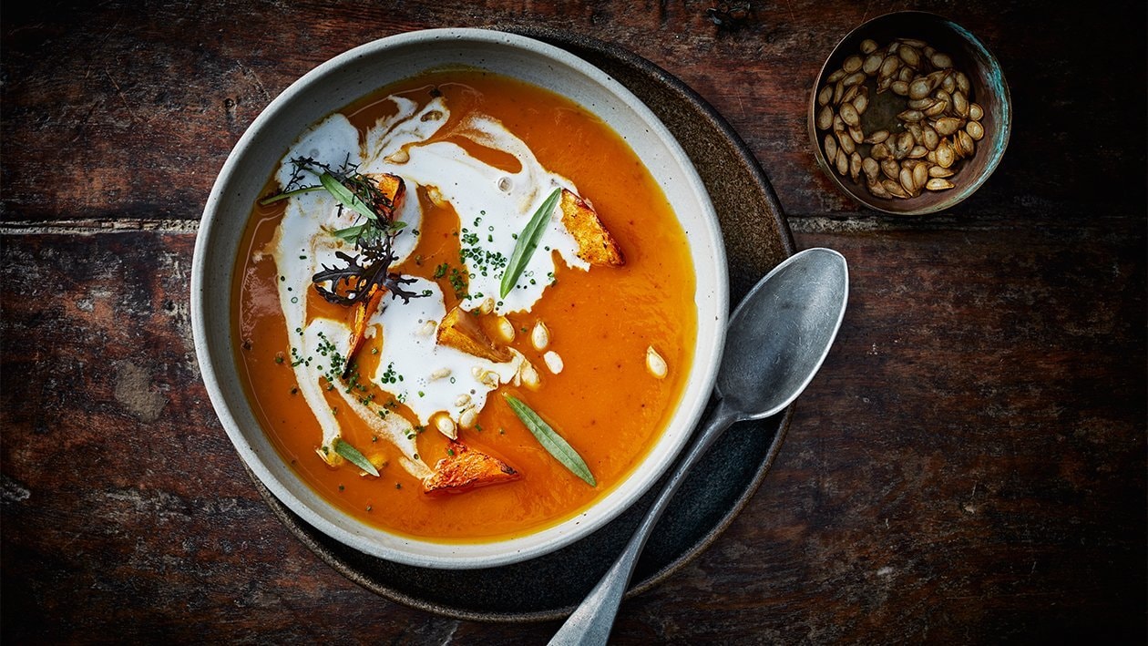 Crème de patates douces et courge au curry thaï jaune, crème de noix de coco et graines de courge dorées
