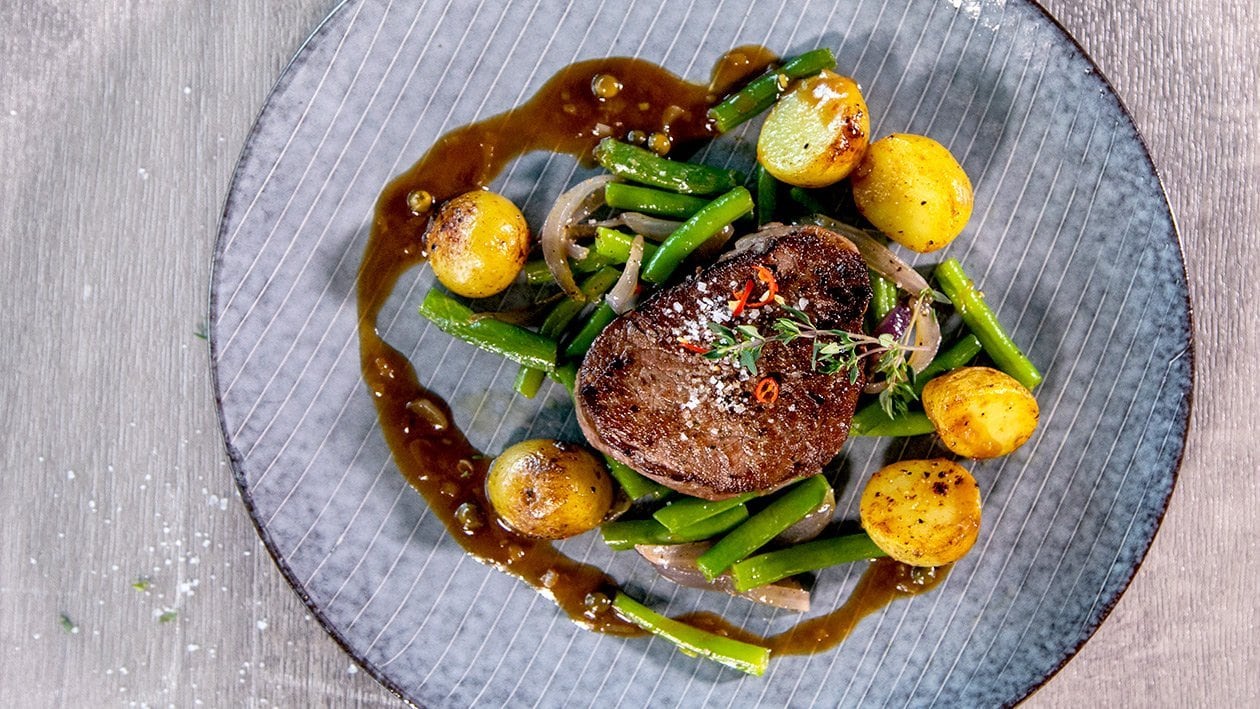 Médaillon de filet de boeuf juteux et rosé, sauce au poivre, pommes nouvelles et haricots verts