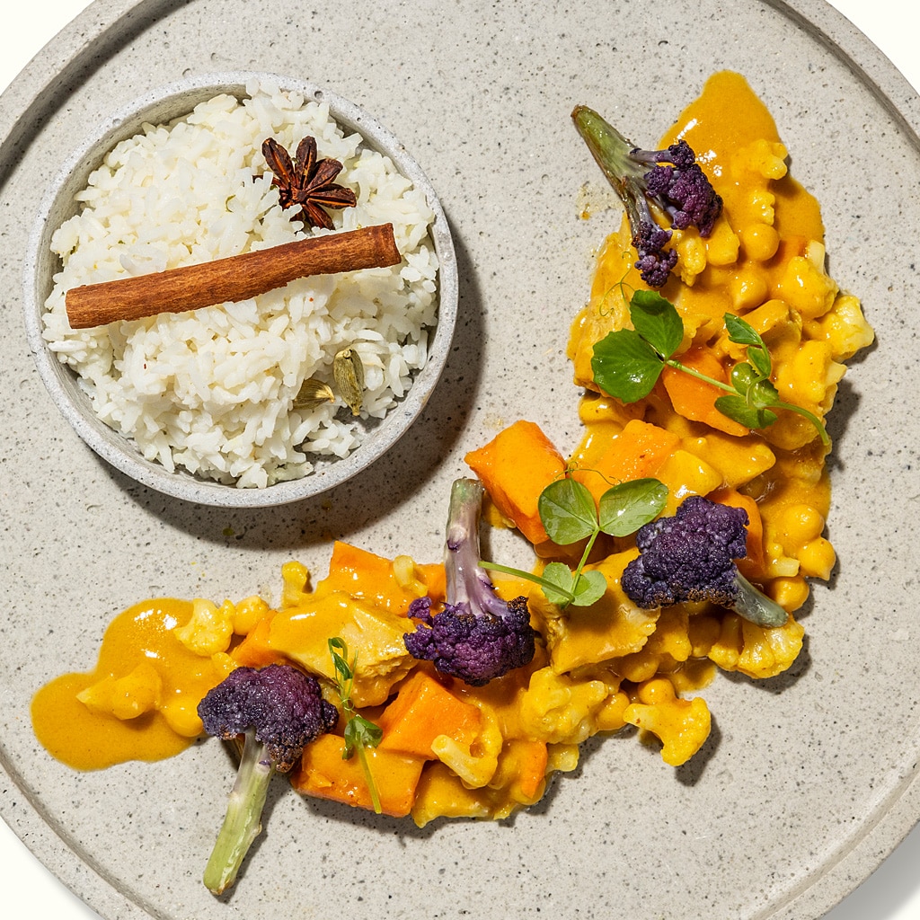 Gelbes Pflanzencurry mit violettem Blumenkohl und würzigem Jeerareis